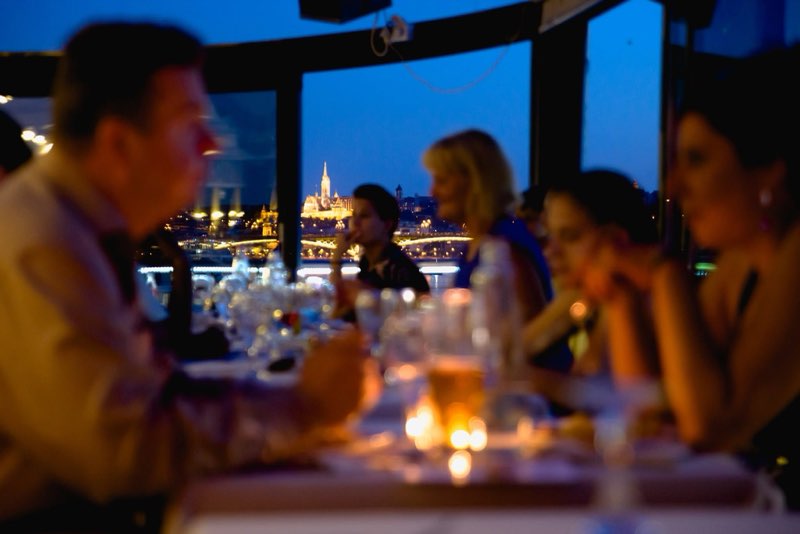 Gyertyafényes vacsora a panorámás teraszon, háttérben a kivilágított Budai Vár